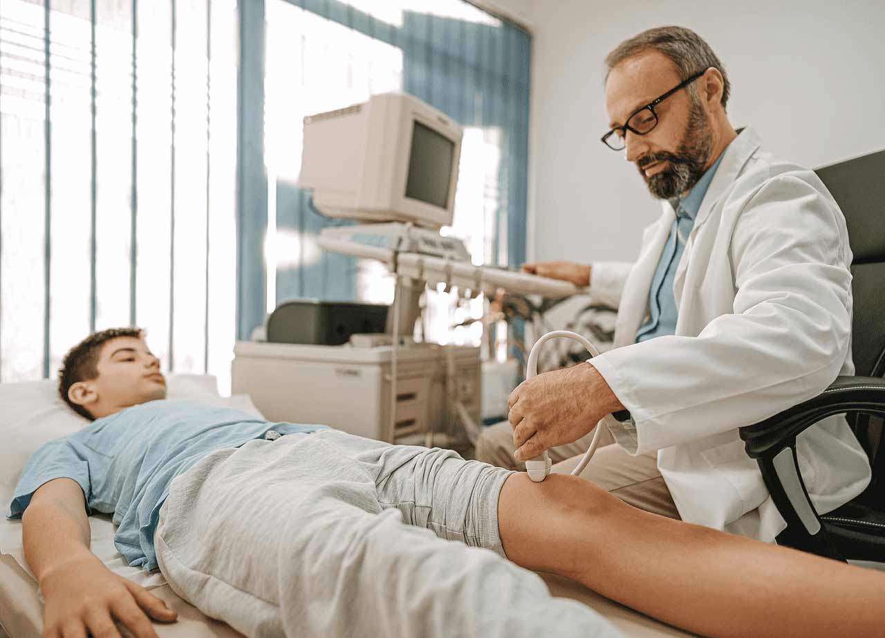 Physician assistant monitoring knee of patient